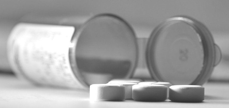 black and white photo of pills and pill bottles